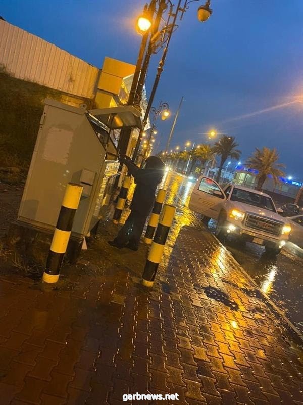 صورة لفني كهرباء يعمل تحت الأمطار بجازان لضمان استمرار الخدمة