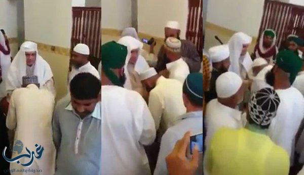 مصلون يتبركون بإمام مسجد بمكة بتقبيل يده والشرب من أثره