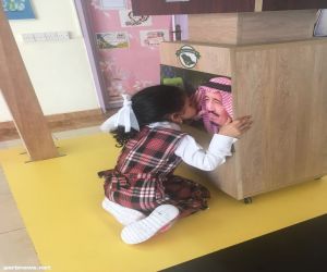 طفلة يتيمة تقبل صورة الملك سلمان